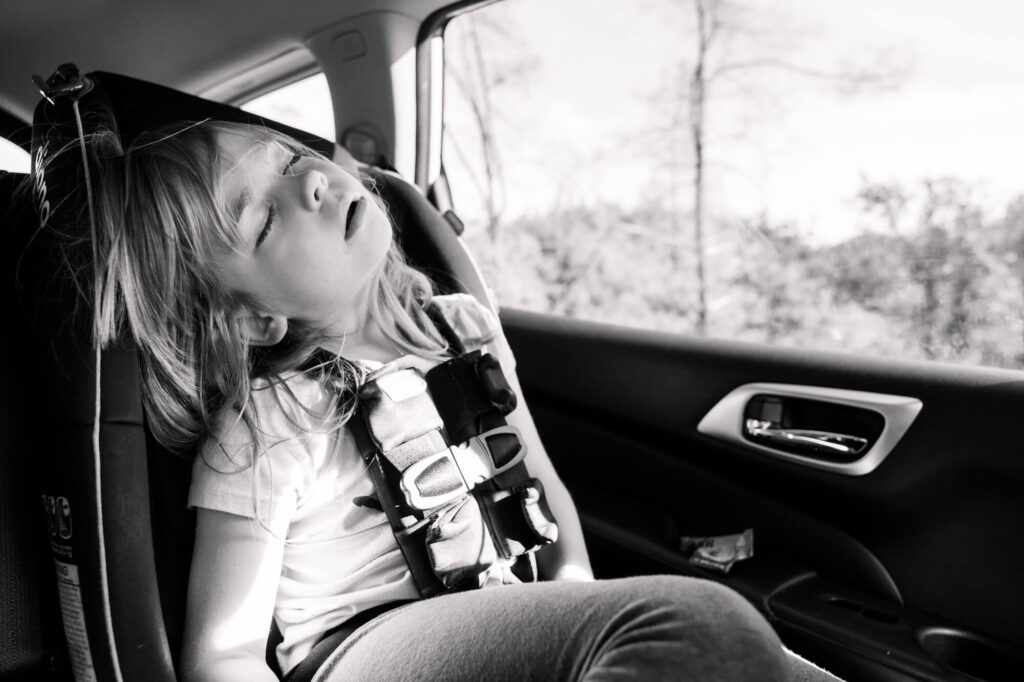 Little girl asleep in car on the way back to Carmichael, CA during a family documentary photography session