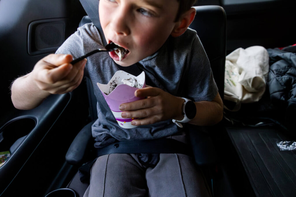 Boy eating a McFlurry from a McDonalds in Carmichael after long hike