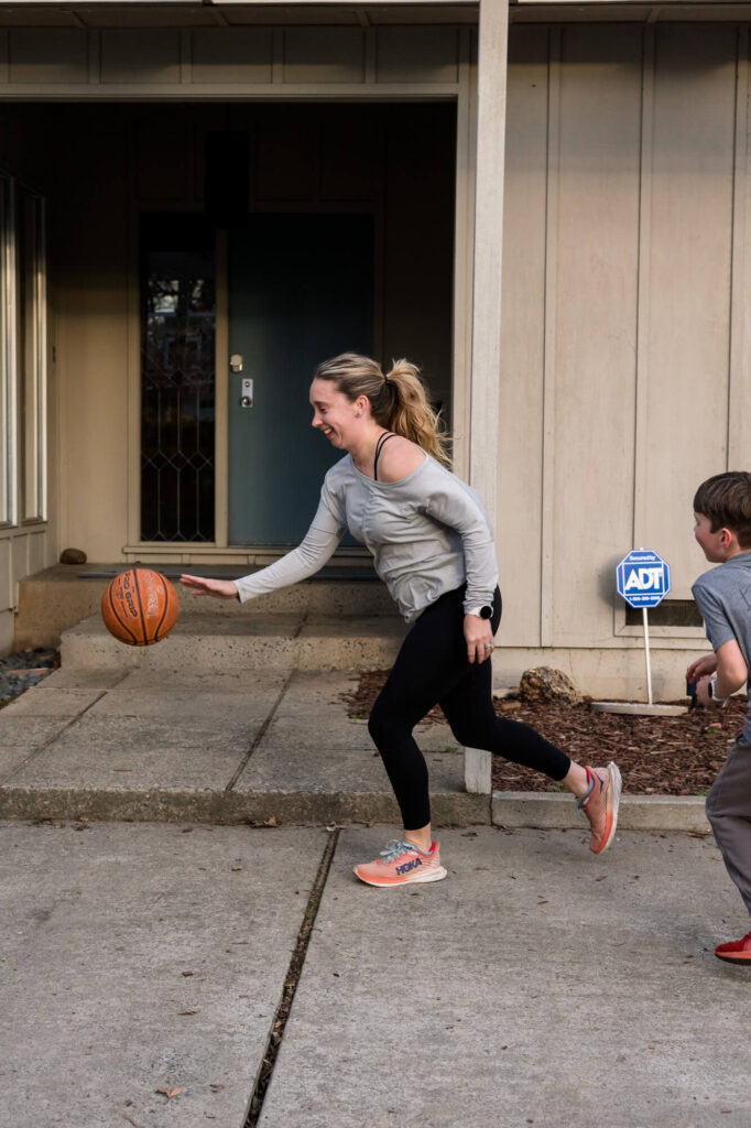 Mom running and dribbling a basketball as son chases behind her